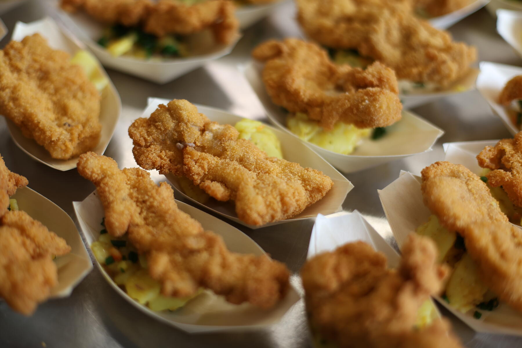 Frisch frittierte Haehnchen-Bites in Papierschalen aus der Kueche des CARYMEL fight & bite